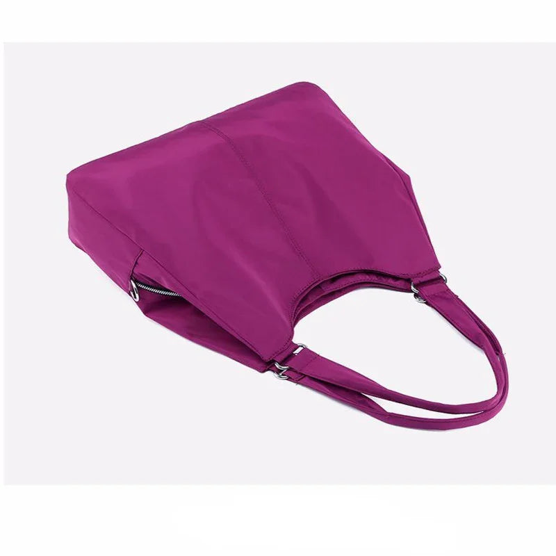 Purple tote bag with double shoulder straps and side zipper pocket on white background