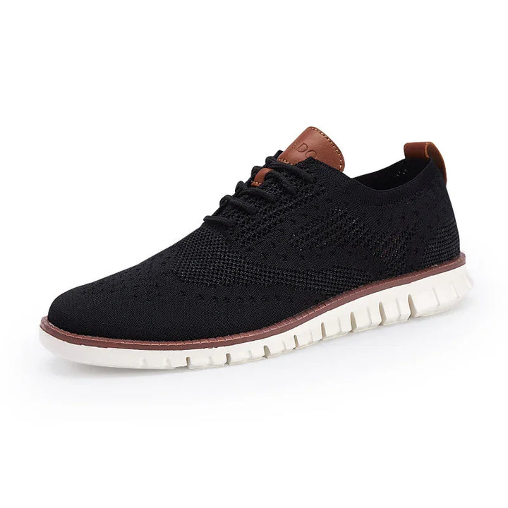 Black knitted casual men's shoe with white flexible sole and brown leather accents