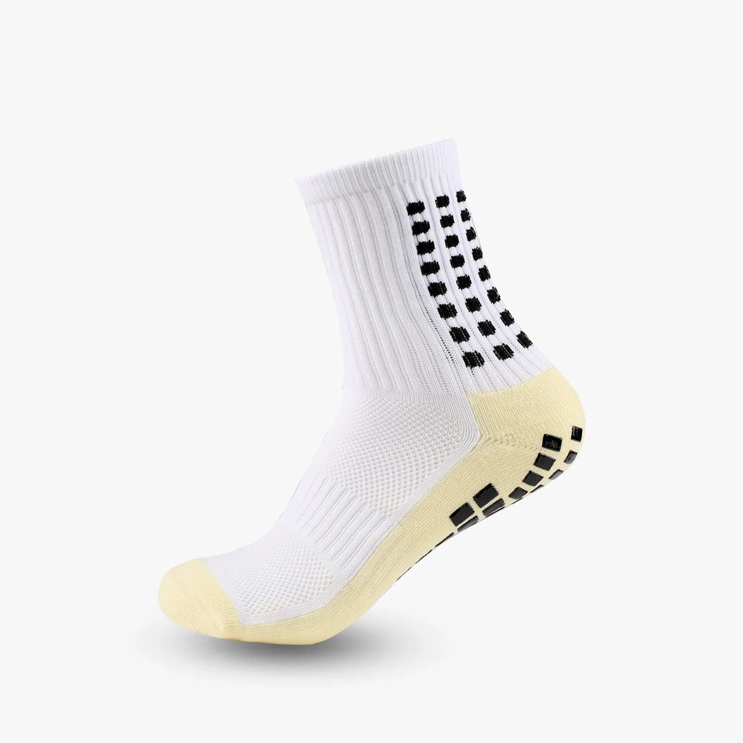 White athletic sock with black grip dots and beige toe and heel accents on white background