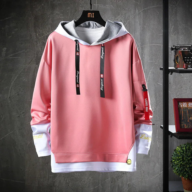 Pink and white layered hoodie with black drawstrings and red sleeve tag on black hanger