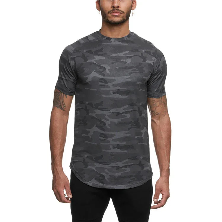 Man wearing fitted dark gray camo print athletic T-shirt with short sleeves against white background