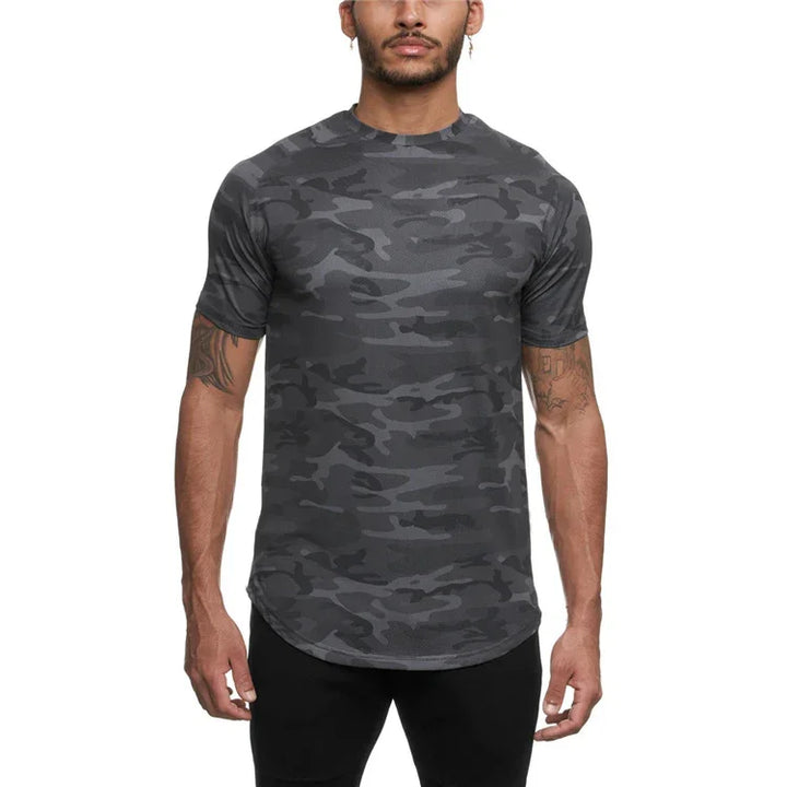Man wearing fitted dark gray camo print athletic T-shirt with short sleeves against white background