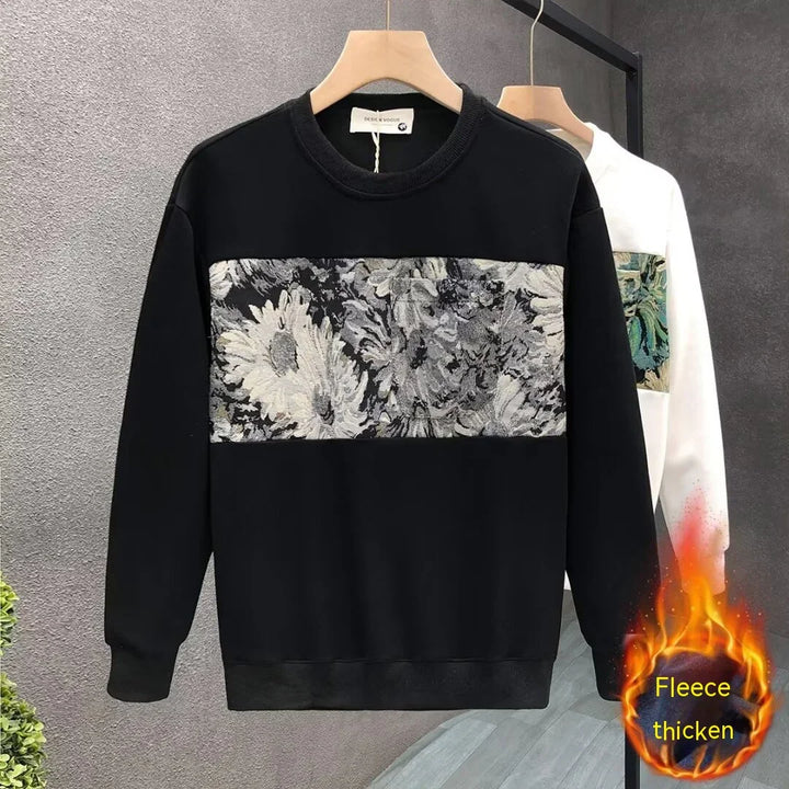 Black fleece sweatshirt with gray floral panel on chest, displayed on wooden hanger indoors