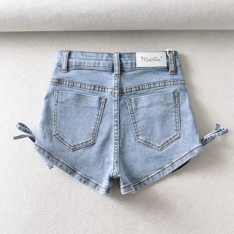 Light blue high-waisted denim shorts with back pockets and side ties on white background