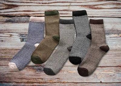 Set of five patterned woolen socks in various earth tones on rustic wooden background