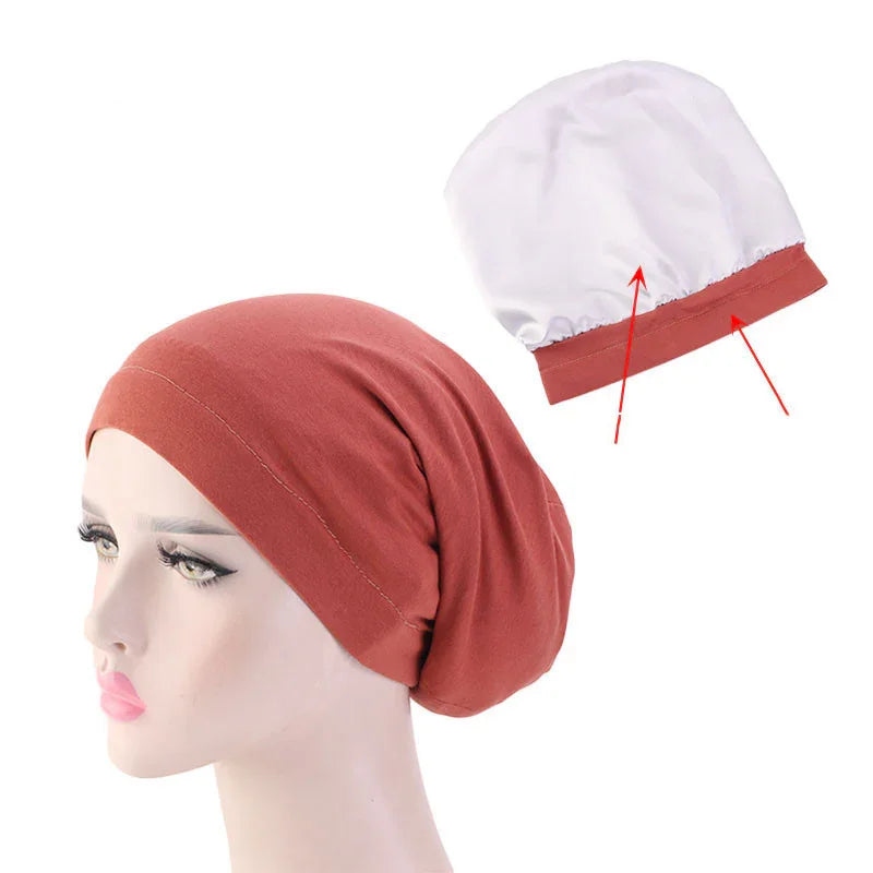 Rust colored cotton chemo beanie cap on mannequin with white inner lining showing elastic band