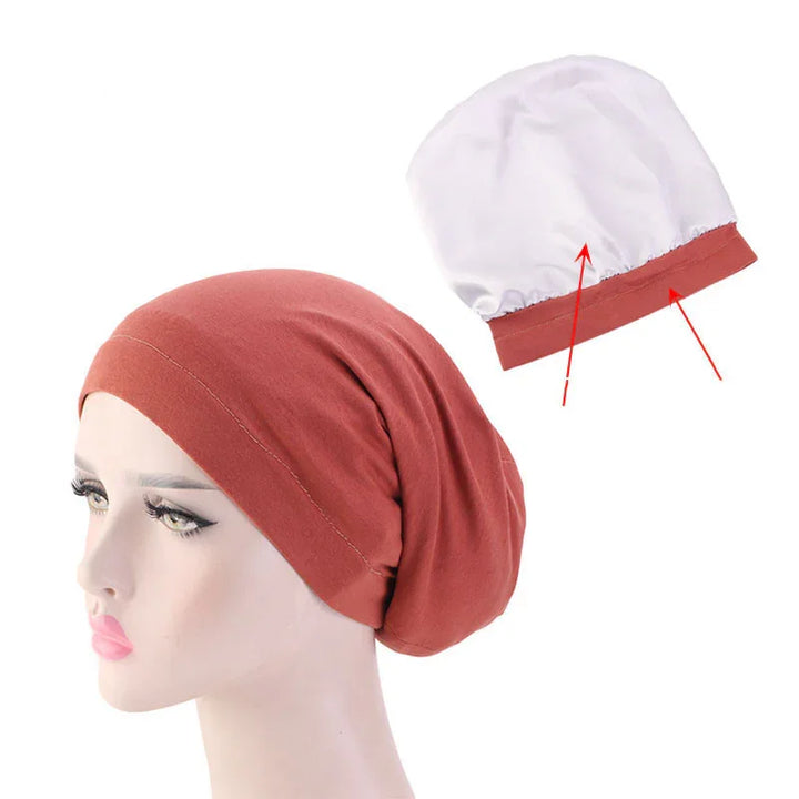 Rust colored cotton chemo beanie cap on mannequin with white inner lining showing elastic band