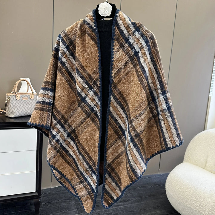Brown plaid woolen shawl with navy trim displayed on a mannequin in a modern room