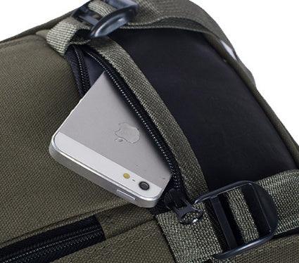 Silver smartphone partially tucked in zippered pocket of olive green fabric backpack