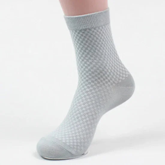 Light gray checkered ankle sock on a foot with a ribbed cuff, seamless toe design