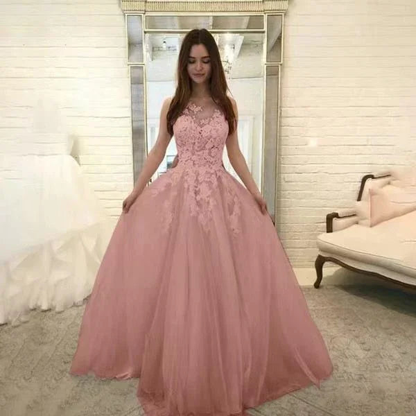 Young woman in pink lace ball gown standing in elegant room with mirror and white sofa