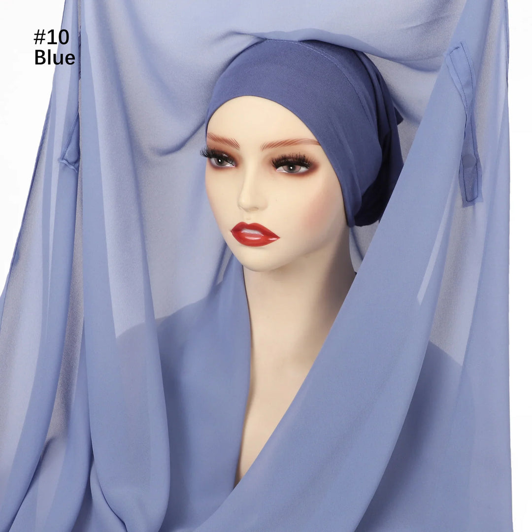 Mannequin head with dark blue inner cap and light blue chiffon hijab draped around