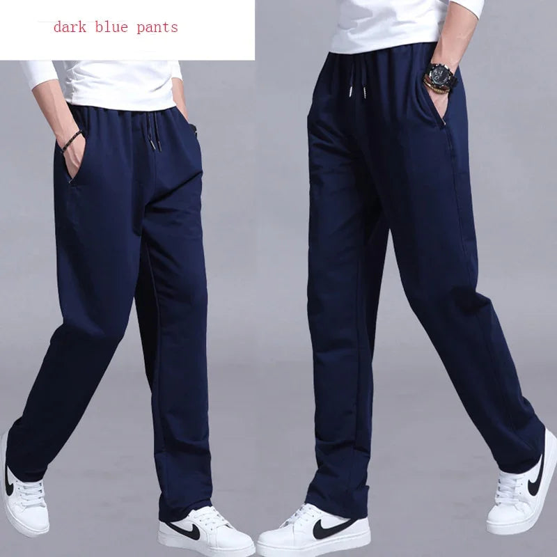 Men's dark blue casual pants with drawstring waist, paired with white Nike sneakers and white top