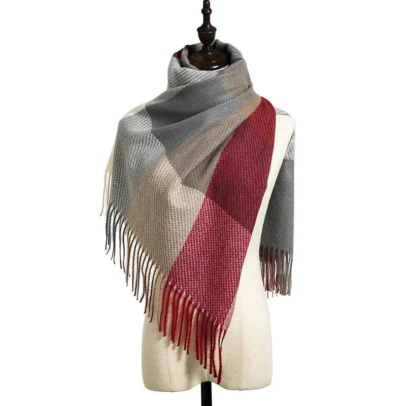Woolen plaid scarf with red, beige, and gray squares draped on a mannequin with fringe edges