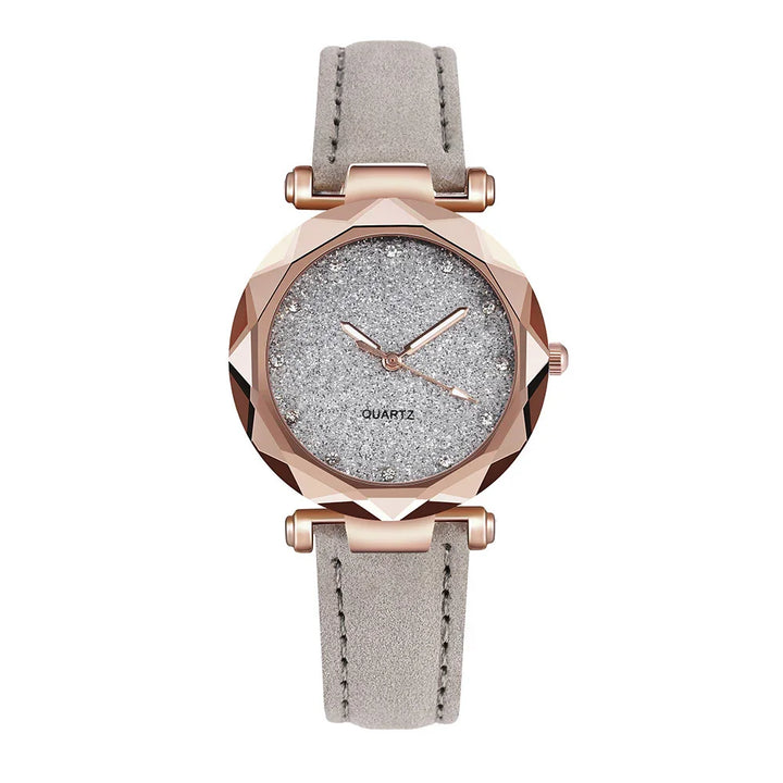 Women's quartz wristwatch with rose gold faceted case and sparkly silver dial on gray suede strap