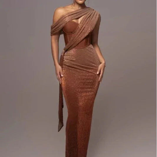 Woman wearing a shimmering copper-colored, one-shoulder evening gown with a fitted corset top