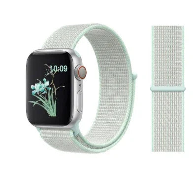 Silver smartwatch with digital flower display and mint green woven sport loop band