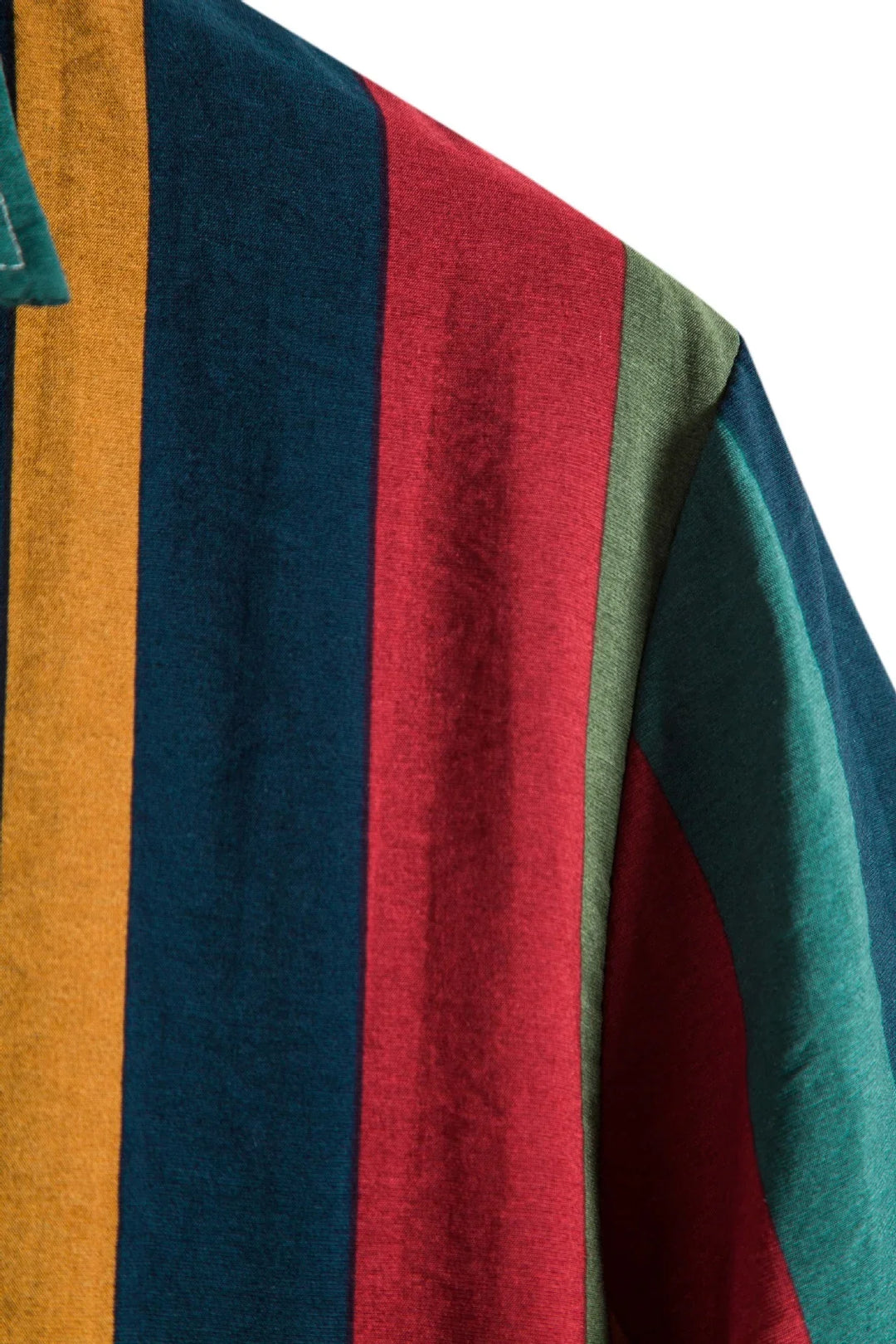 Close-up of fabric with vertical stripes in mustard, navy blue, red, green, and teal colors