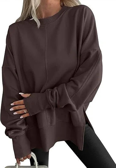Woman wearing oversized dark brown sweatshirt with crew neck and long sleeves, paired with black leggings