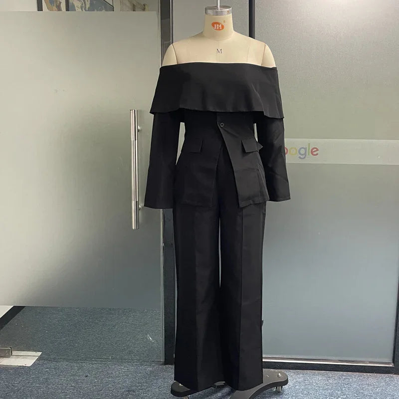 Black off-shoulder blazer and wide-leg pants on mannequin in office setting