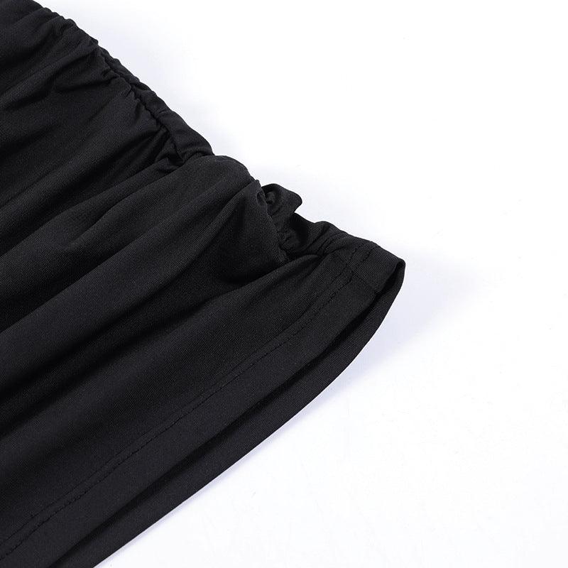 Close-up of black elastic waistband on black fabric clothing against white background