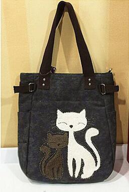 Dark gray tote bag with black straps featuring embroidered white and brown cats on front