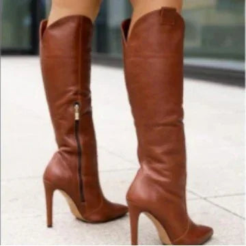 Woman wearing stylish brown leather knee-high boots with high heels and side zipper on sidewalk