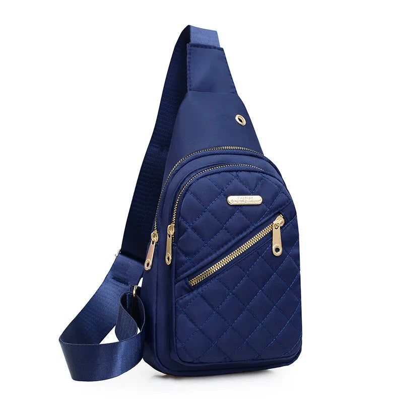 Navy blue quilted crossbody sling bag with gold zippers and adjustable strap