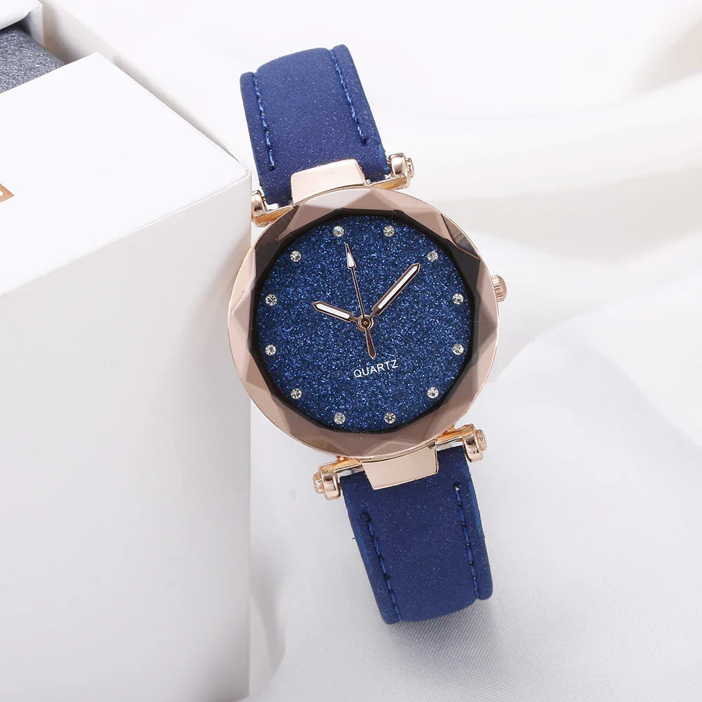 Elegant blue quartz wristwatch with glittery dial and gold-tone bezel on white background