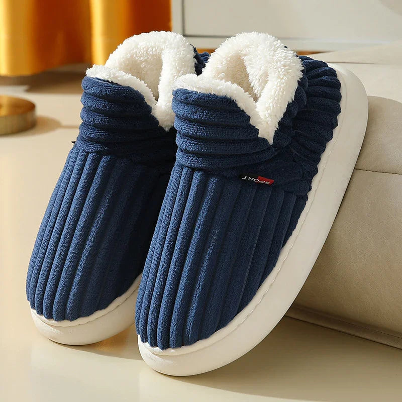 Cozy navy blue ribbed slippers with white fleece lining and white soles on a beige surface