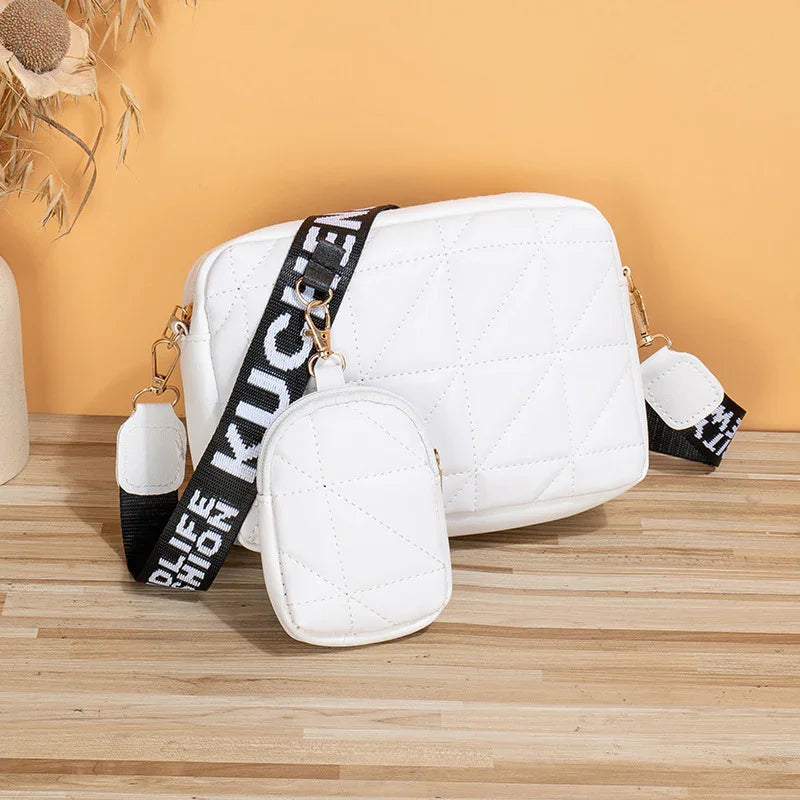 White quilted crossbody bag with matching small pouch and black adjustable strap on wooden surface