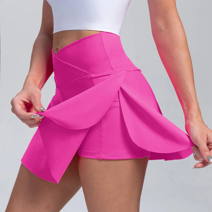 Close-up of woman wearing bright pink high-waisted athletic skort with built-in shorts and petal hem