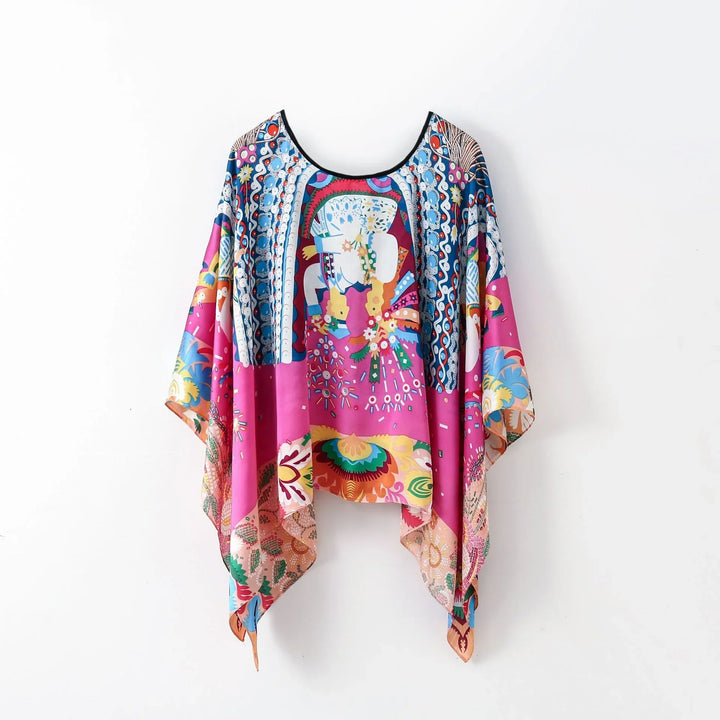 Colorful silk poncho with vibrant floral and abstract patterns on white background