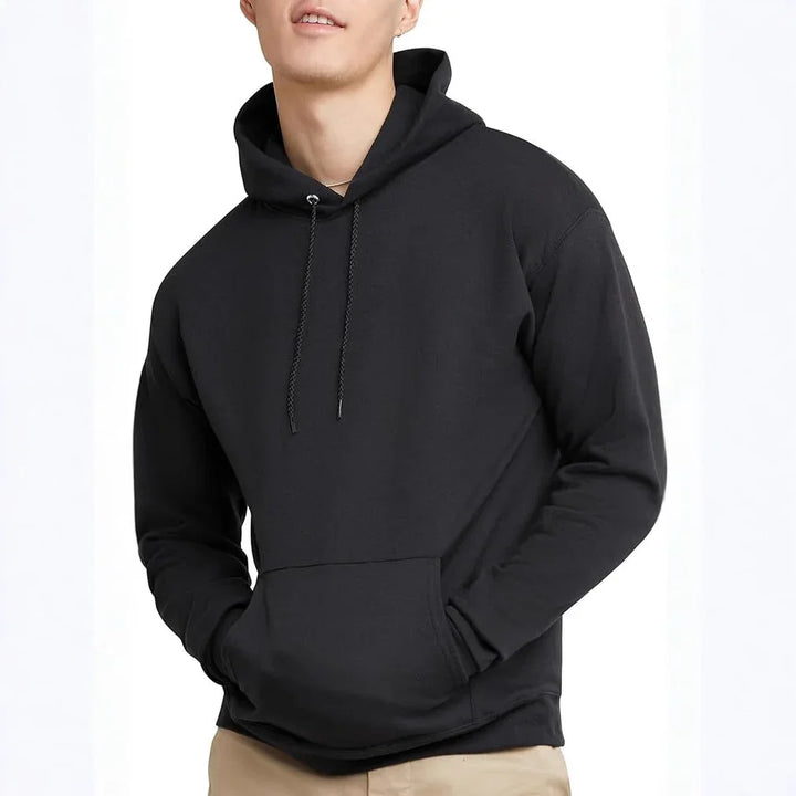 Man wearing plain black hoodie with drawstrings and kangaroo pocket, beige pants, white background