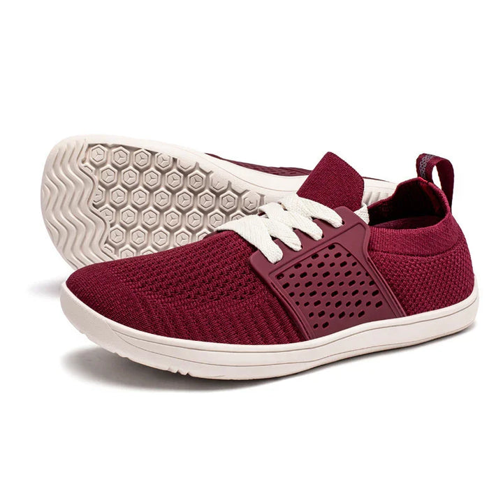 Pair of maroon knit sneakers with white laces and beige rubber soles featuring hexagonal tread pattern