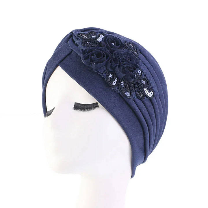 Navy blue turban headwrap with floral fabric and sequin embellishments on mannequin