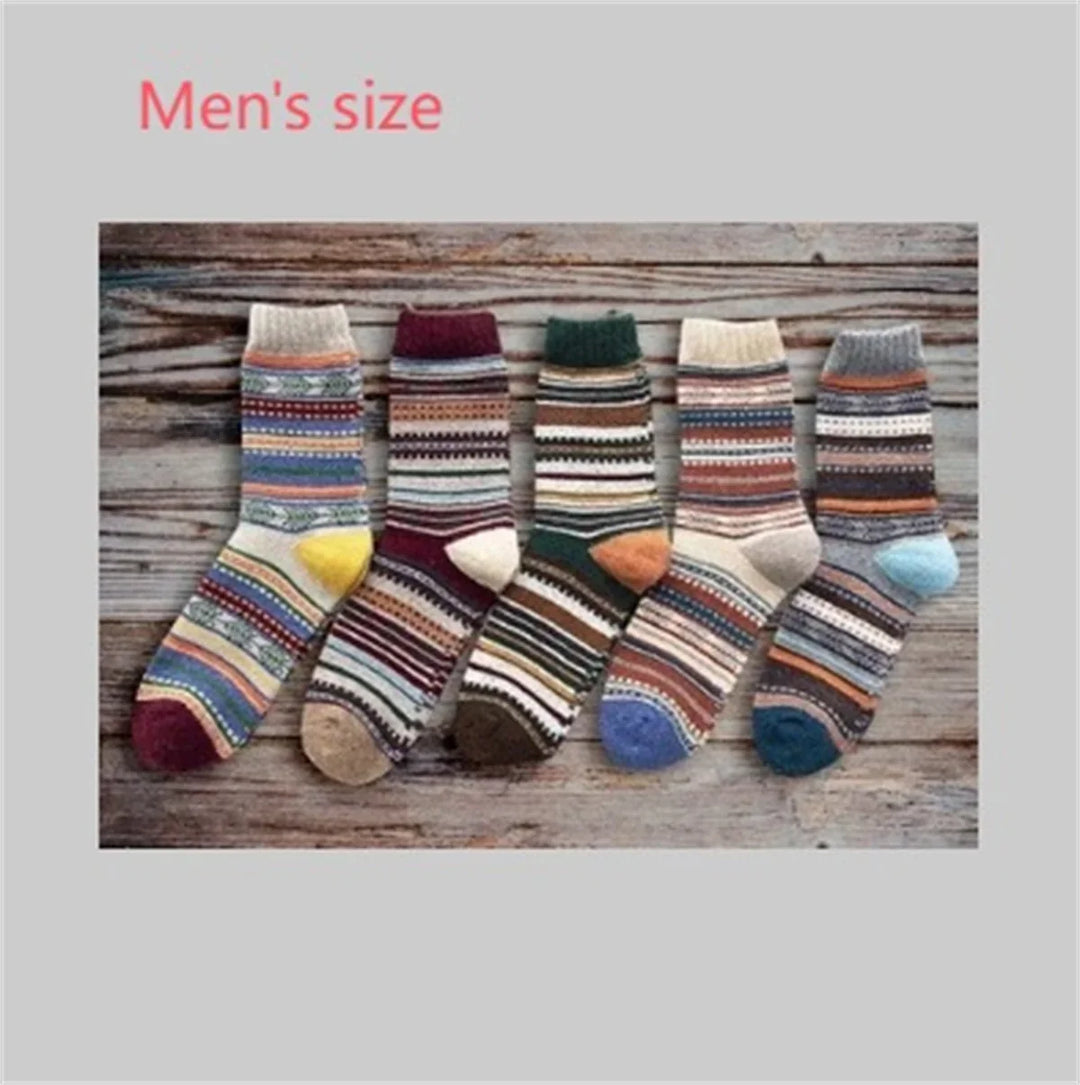 Five pairs of colorful men's knit patterned socks with stripes and geometric designs on wooden background