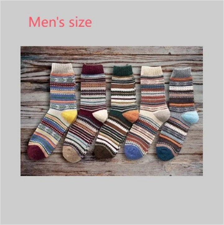 Five pairs of colorful men's knit patterned socks with stripes and geometric designs on wooden background
