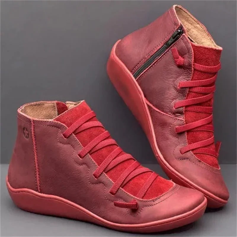 Red leather and suede high-top sneakers with side zipper and unique lace design on gray background