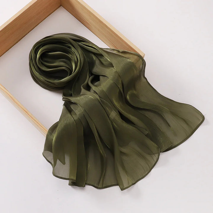 Olive green sheer chiffon scarf displayed on a wooden frame over a white background