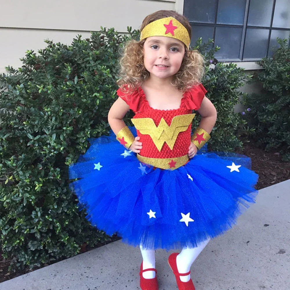 Little girl in vibrant Wonder Woman costume with red, gold, and blue tutu standing outdoors