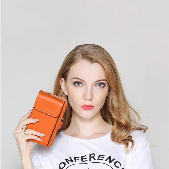 Blonde woman holding bright orange leather wallet against gray background