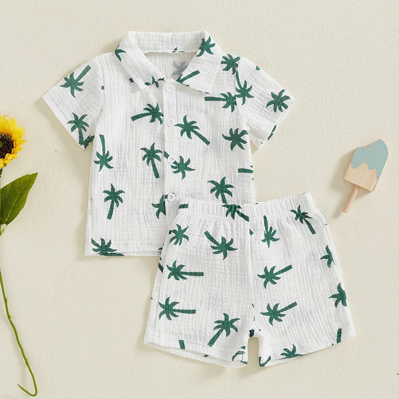 White baby shirt and shorts set with green palm tree print, short sleeves, and buttons