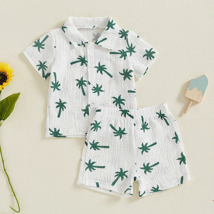 White baby shirt and shorts set with green palm tree print, short sleeves, and buttons