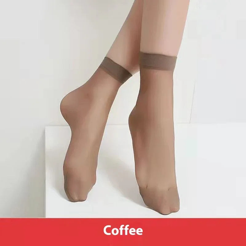 Pair of legs wearing sheer coffee-colored ankle socks against white background