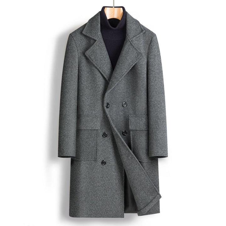 Gray men's double-breasted wool coat on wooden hanger over black turtleneck sweater