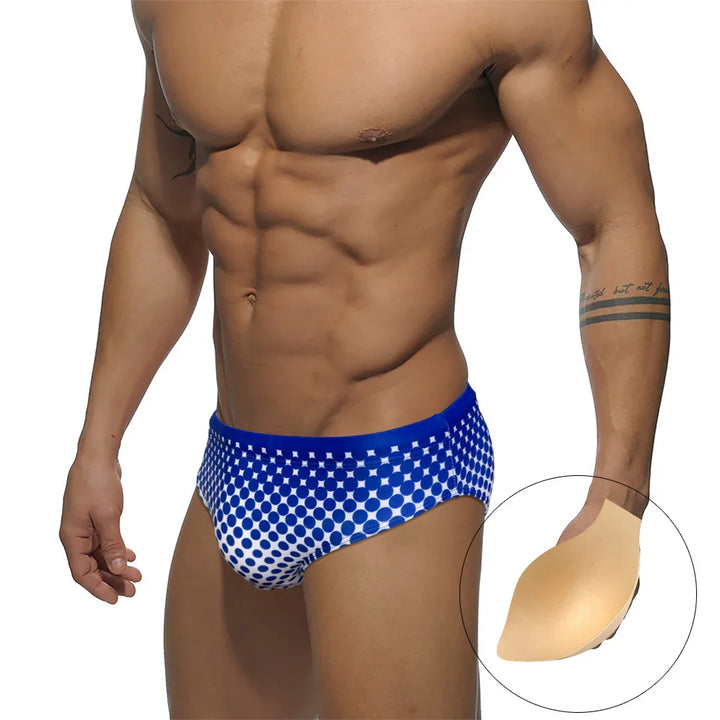 Muscular man wearing blue and white polka dot briefs with beige swim cup shown