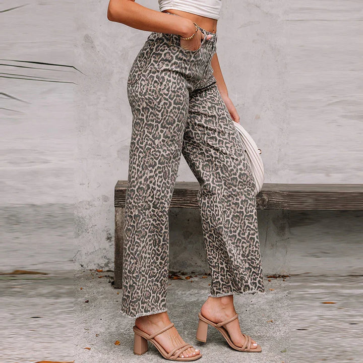 Woman wearing high-waisted leopard print pants and beige block heel sandals standing outdoors