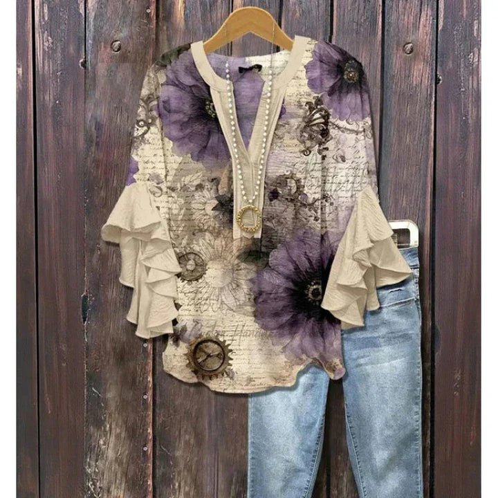 Vintage floral blouse with purple flowers and ruffled sleeves paired with blue denim jeans on hanger