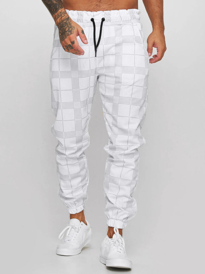 Man wearing white plaid jogger pants with black drawstring and white sneakers